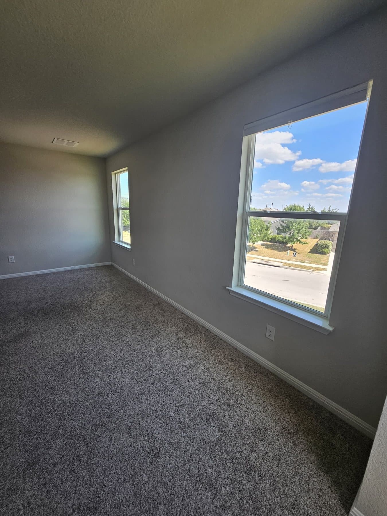 Freshly painted bedroom with a large window looking out to the street
