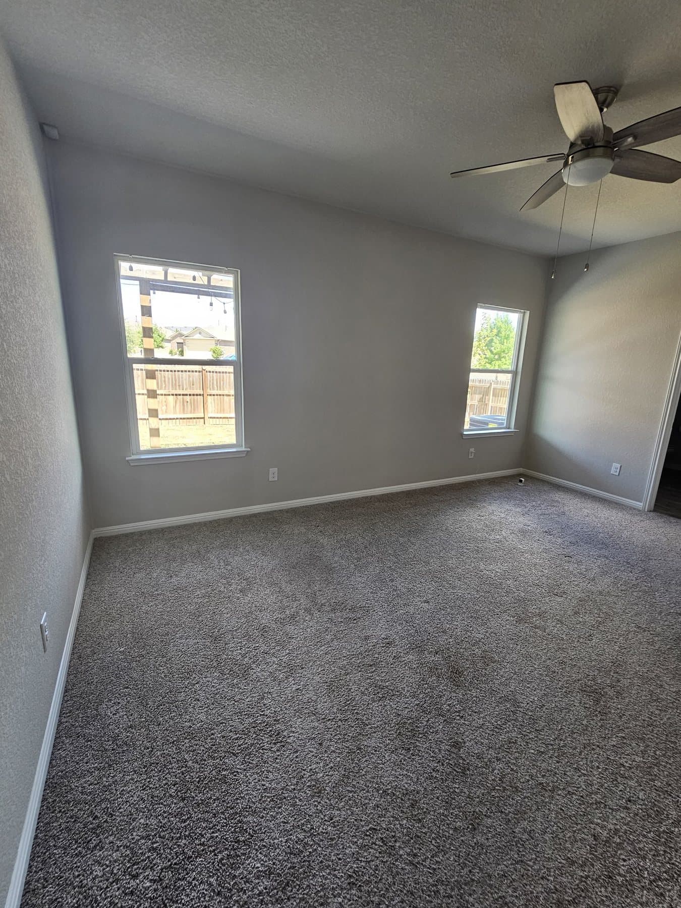 Freshly painted bedroom with vaulted ceiling and two windows