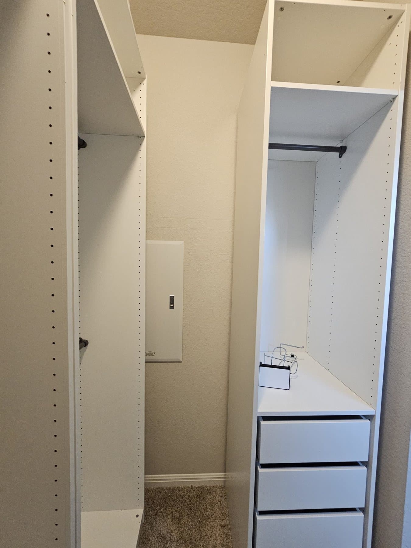 Freshly painted walk-in closet with white built-in shelving and drawers