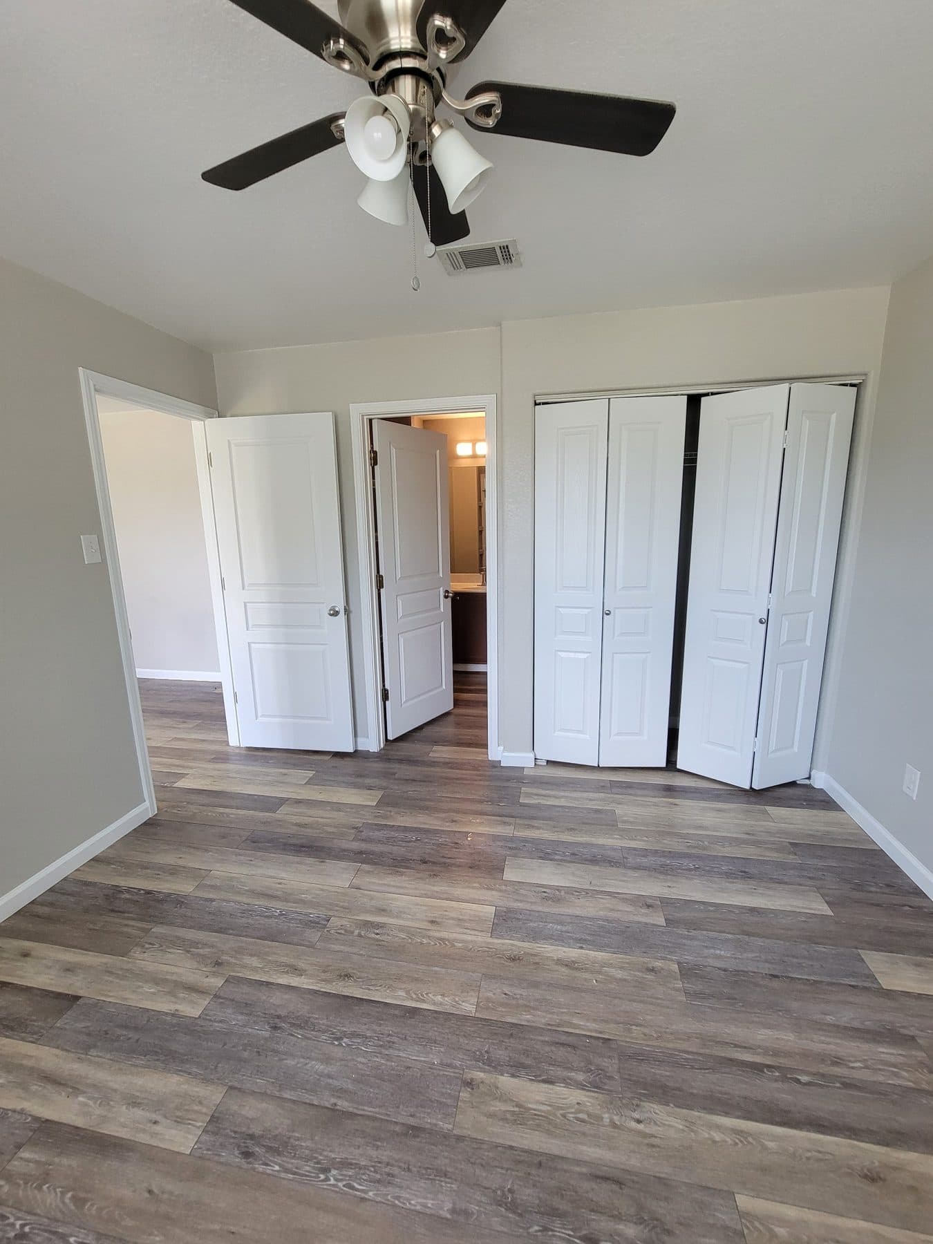 Room with newly installed wood-look plank flooring and white trim