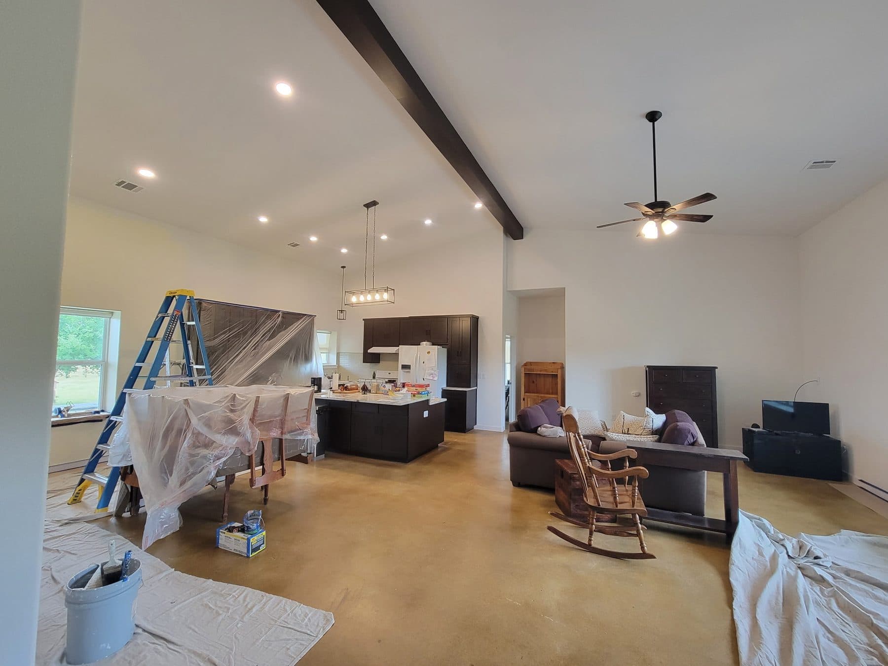 Large open plan kitchen and living area prepared for interior painting